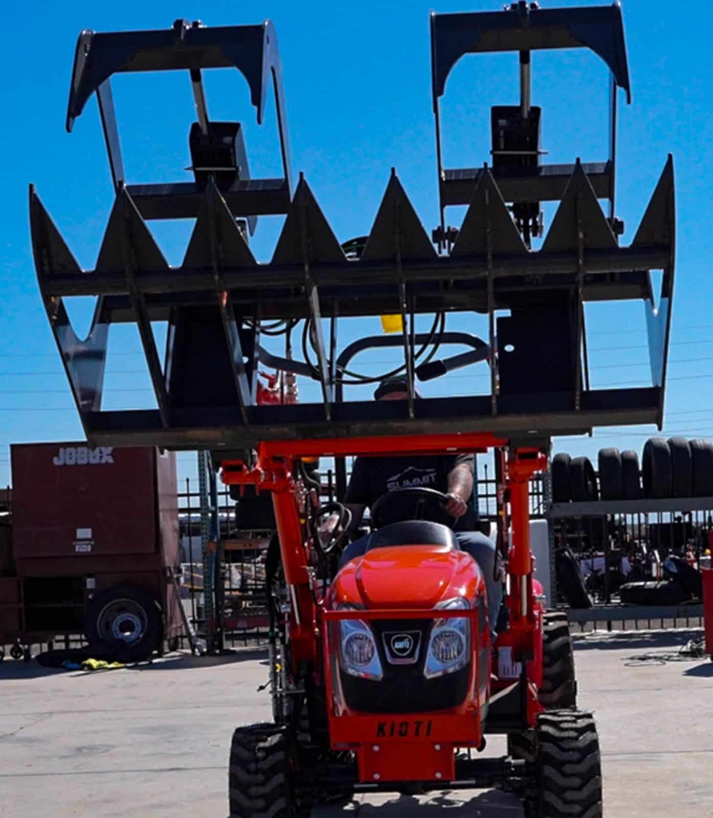 Kioti CX2510 Tractor using a grapple